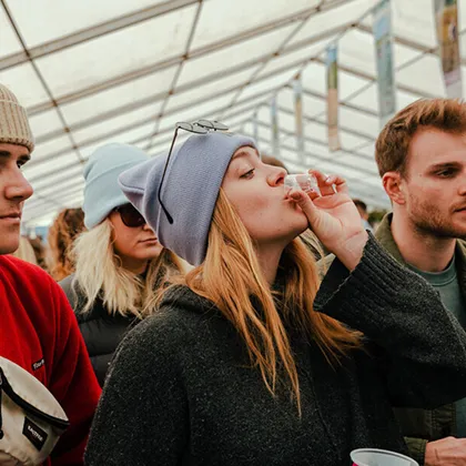 Festival-goers enjoying drinks inside one of the marquees